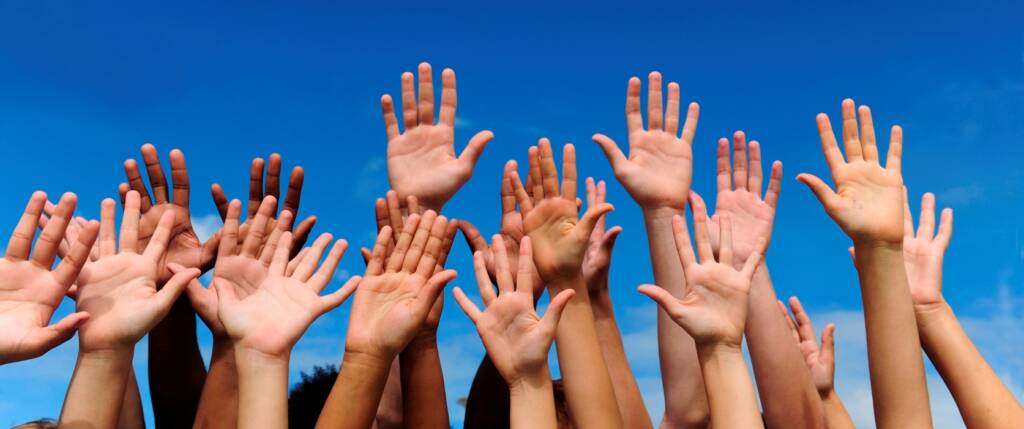People raising hands to volunteer